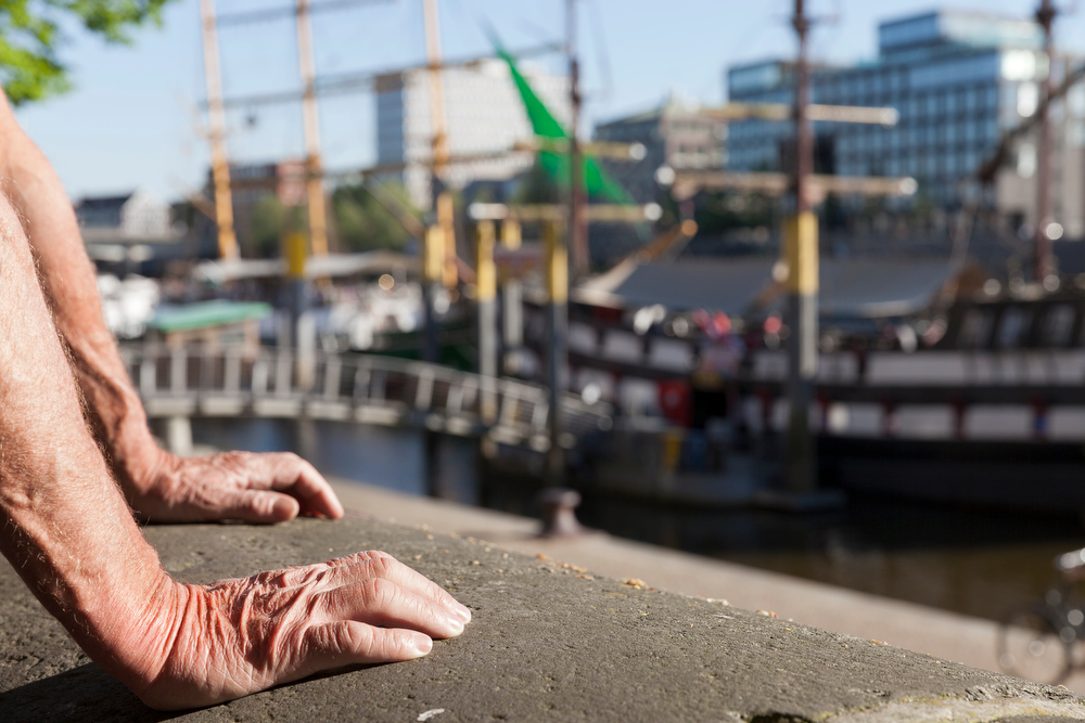 Hände eines Teilnehmers mit Blick auf Hafen