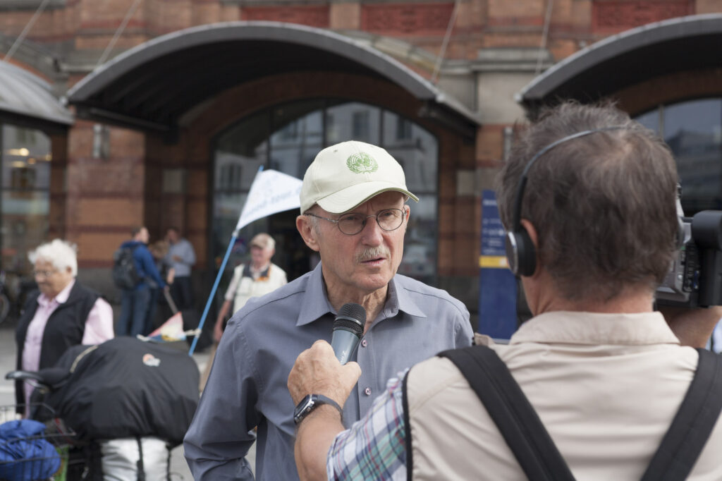 Willi Lemke als Schirmvater der MUT-TOUR 2012 bei einem Interview vorm Bremer HBF