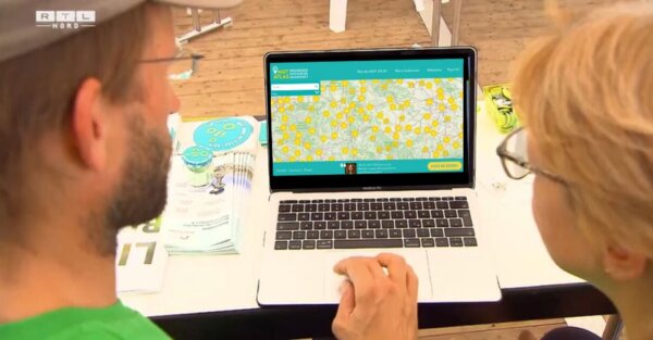 Zwei Menschen schauen auf einen Laptop-Bildschirm, an dem der MUT-ATLAS geöffnet ist.
