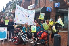 Menschen mit MUT-TOUR-Schildern und einem Banner mit bunten Handabdrücken bei einem Aktionstag in Bremervörde