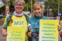 Zwei Frauen halten MUT-TOUR-Schilder auf Arabisch und Russisch hoch. (c) Joerch Merkel