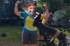 Eine MUT-TOUR-Teilnehmerin macht eine Kraftpose, ihr Kopf wird vom Spiegelbild einer anderen Teilnehmerin im Tandem-Spiegel überdeckt