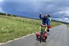 Zwei Menschen fahren auf einem bepackten Tandem der MUT-TOUR über einen Feldweg