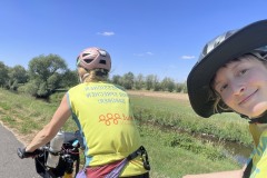 Zwei Frauen sitzen auf einem Tandem, eine lächelt in die Kamera