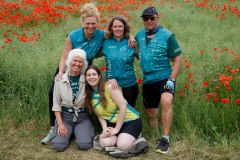Ein Etappen-Team der MUT-TOUR 2026 seht vor einem Mohnfeld (c) Sebastian-Burger